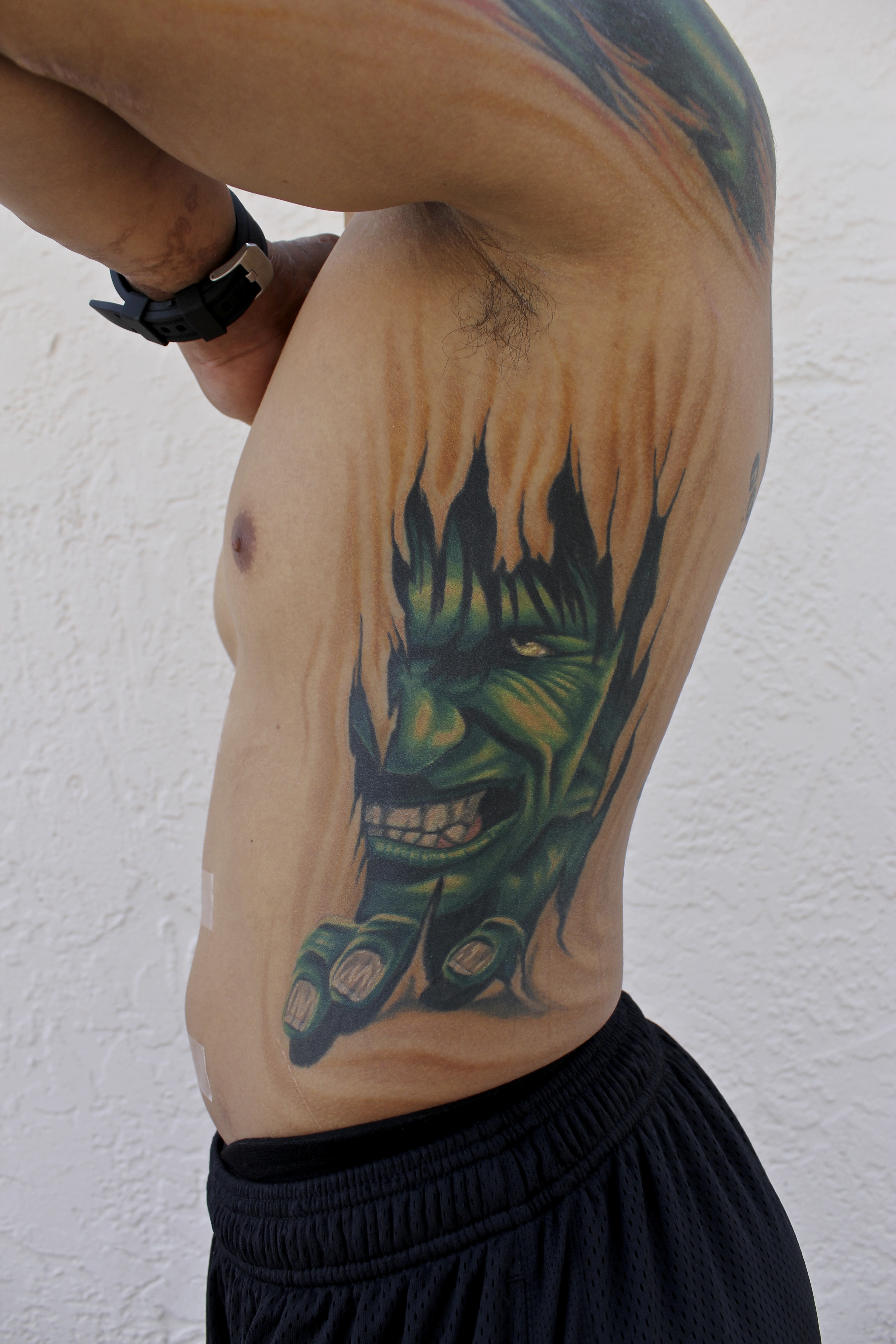 Ripped Skin Hulk Tattoo On Man Side Rib