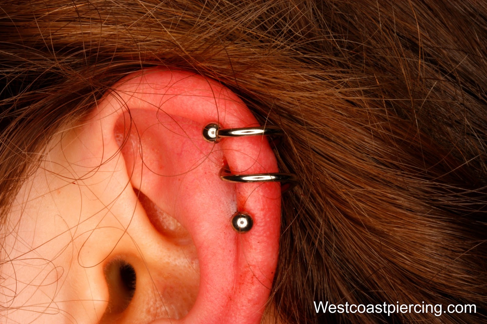 Silver Spiral Piercing On Girl Left Ear Cartilage