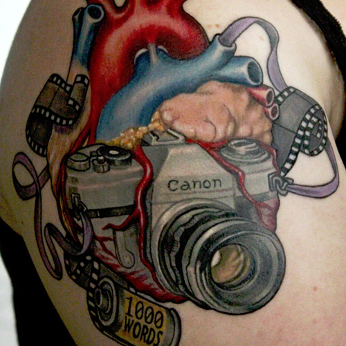 Amazing Real Heart With Camera Tattoo On Right Shoulder