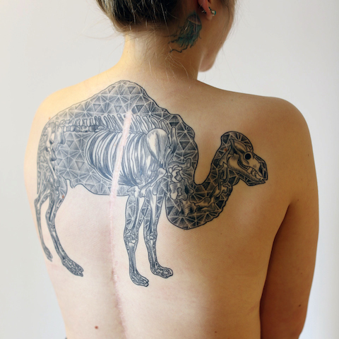 Black Ink Geometric Camel Tattoo On Girl Upper Back