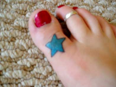 Blue Ink Star Tattoo On Girl Toe