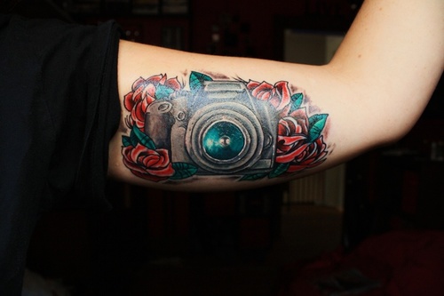 Camera With Red Roses Tattoo On Bicep