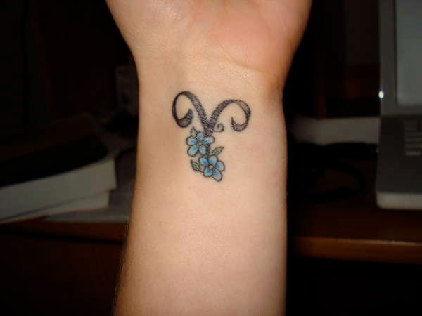 Small Blue Flowers And Aries Tattoo On Wrist