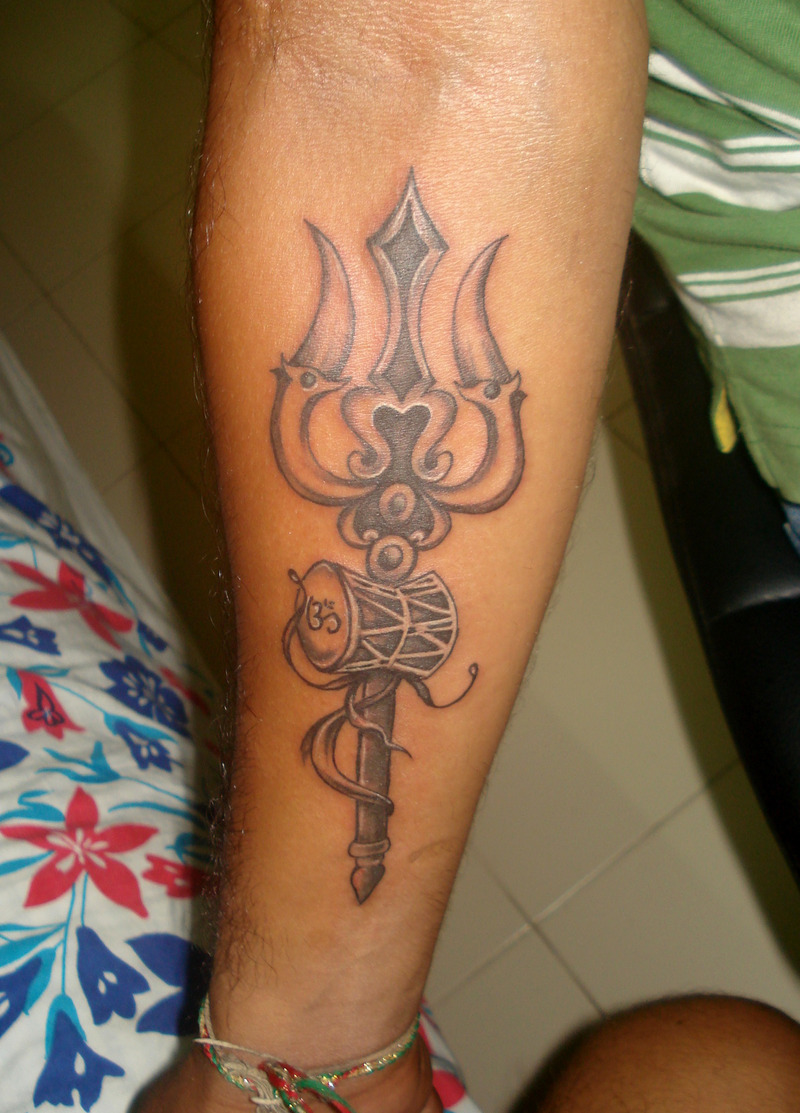 Amazing Black Ink Trishul With Pellet Drum Tattoo On Forearm