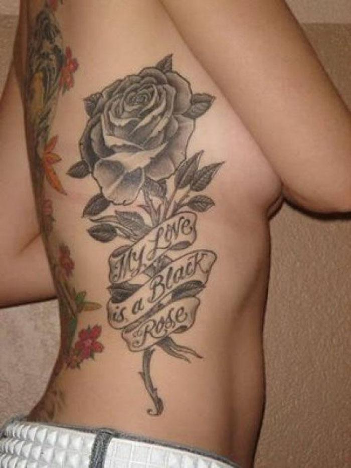 Black And Grey Rose With Thorn And Banner Tattoo On Side Rib