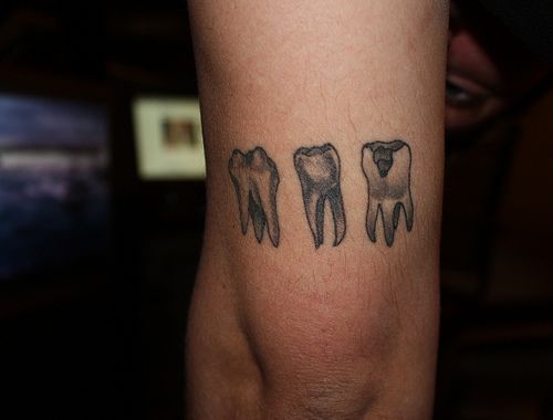 Black And Grey Three Teeth Tattoo Design For Arm