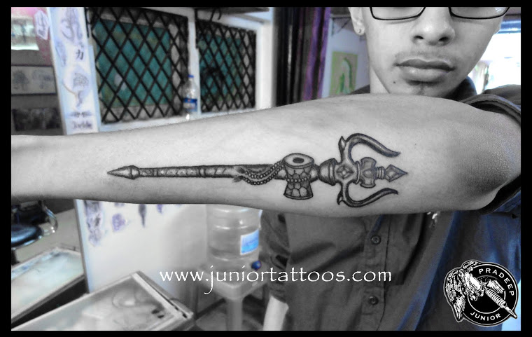 Black And Grey Trishul With Pellet Drum Tattoo On Man Arm