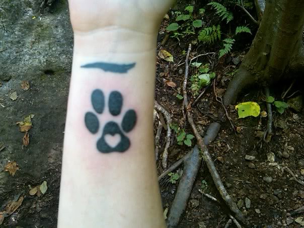 Black Ink Heart In Pug Paw Tattoo On Wrist