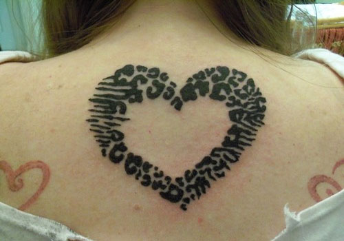 Black Ink Leopard Paw Print Heart Tattoo On Upper Back