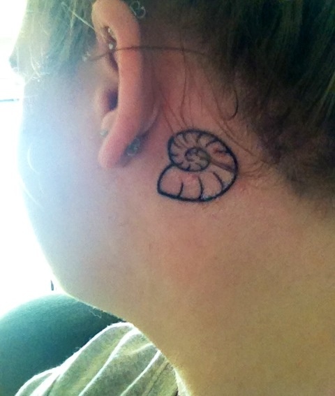 Black Nautilus Shell Tattoo On Girl Behind The Ear