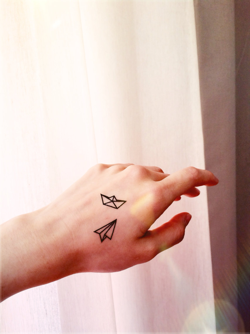 Black Outline Paper Boat And Plane Tattoo Hand