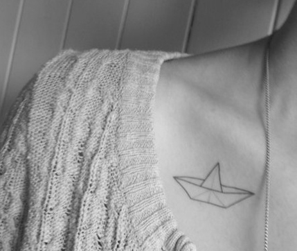Black Outline Paper Boat Tattoo On Girl Collarbone