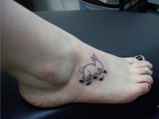 Black Outline Rabbit With Paw Prints Tattoo On Girl Foot By Ducky