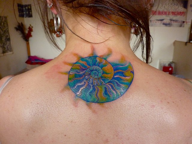 Colorful Spiral Shell Tattoo On Girl Back Neck