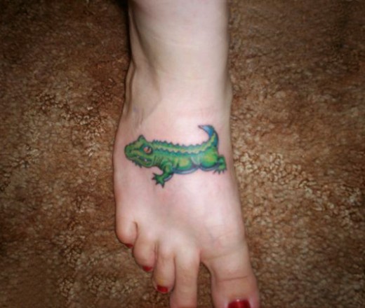 Green Ink Cartoon Crocodile Tattoo On Girl Foot