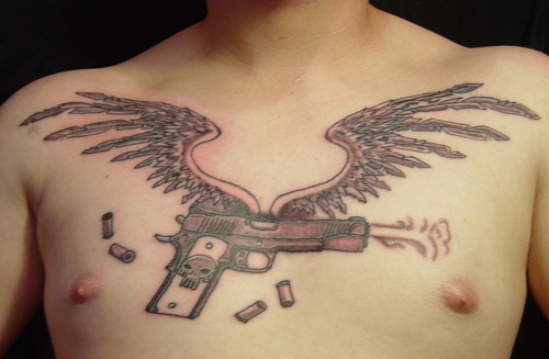 Gun With Wings And Bullets Tattoo On Man Chest