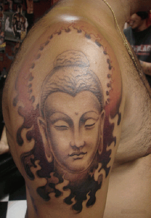 Meditating Buddha head with flames tattoo design on shoulder
