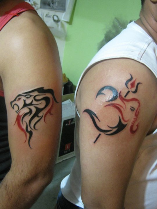 Red And Black Om Trishul Tattoo On Man Right Shoulder