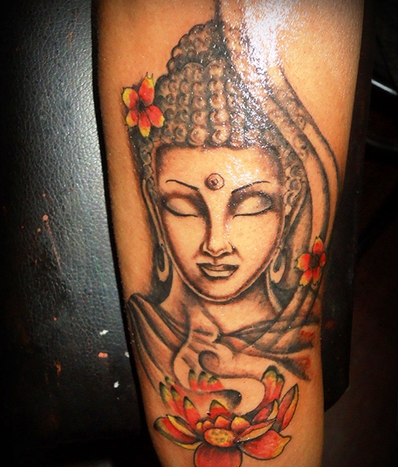 Religious Buddha head tattoo on forearm