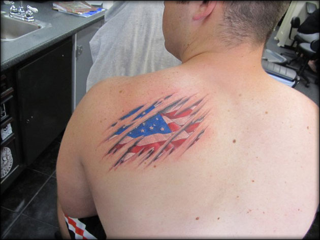 Ripped Skin Patriotic USA Flag Tattoo On Man Left Back Shoulder