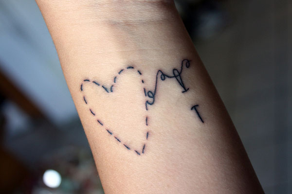 Simple Threaded Heart With  Needle And Thread Tattoo On Wrist
