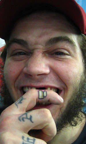 Two Teeth Tattoo On Man Finger