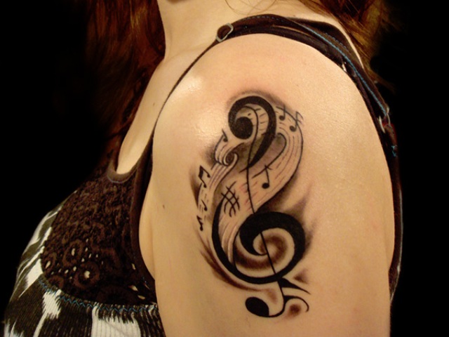 Awesome Black Treble Clef With Music Knots Tattoo On Girl Left Shoulder