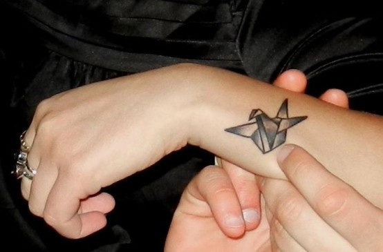 Black Ink Paper Swan Tattoo On Girl Side Wrist