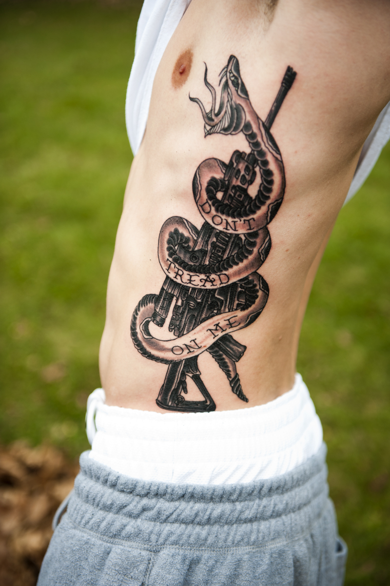 Black Ink Rattlesnake With Gun Tattoo On Man Side Rib By Seanscarmack