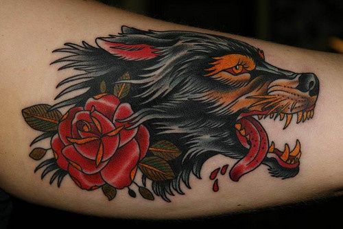 Red Rose And Traditional Wolf Tattoo On Bicep