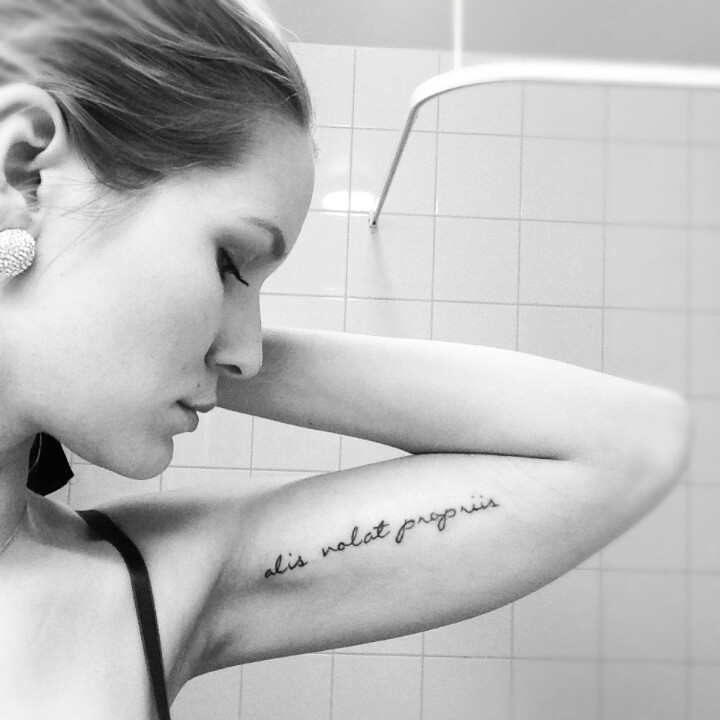 Alis Volat Propriis Lettering Tattoo On Girl Left Bicep