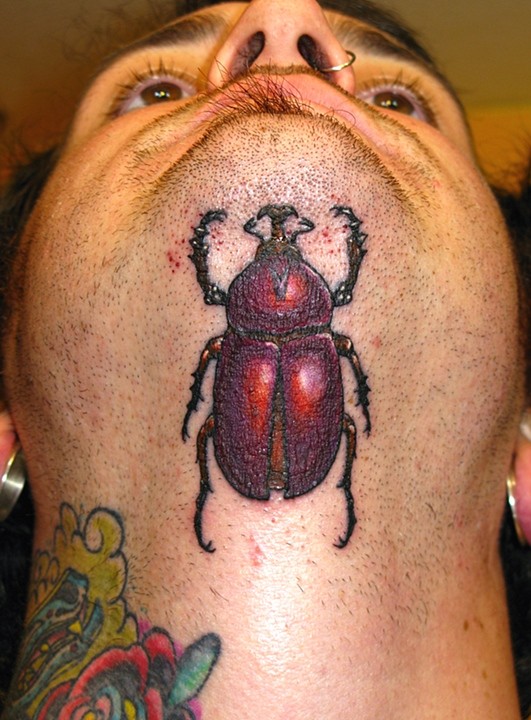 Awesome Beetle Tattoo On Man Under Chin