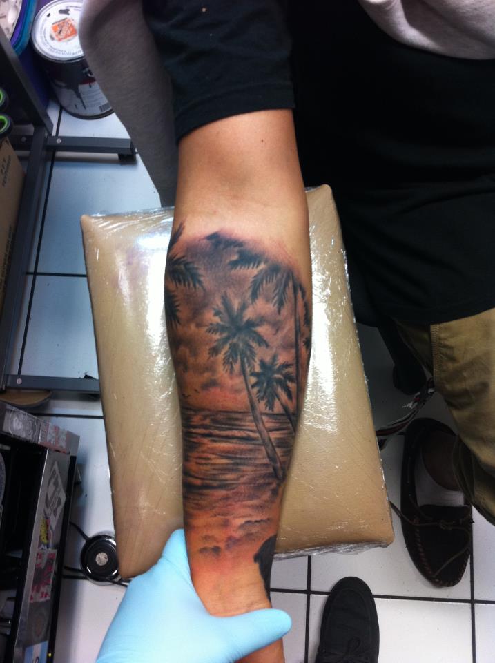 Black And Grey Beach Scene Tattoo On Forearm
