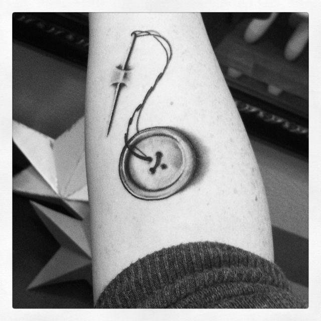 Black And Grey Button With Needle Tattoo Design For Forearm