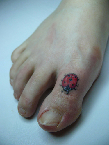 Black And Red Bug Tattoo On Foot Toe