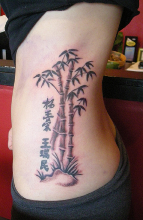 Black Ink Bamboo Trees Tattoo On Girl Side Rib