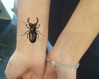 Black Ink Beetle Tattoo On Wrist