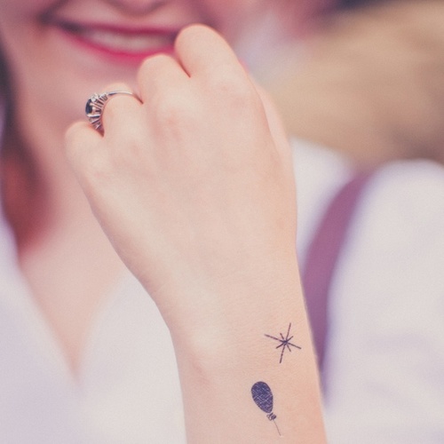 Black Little Balloon Tattoo On Girl Upper Wrist