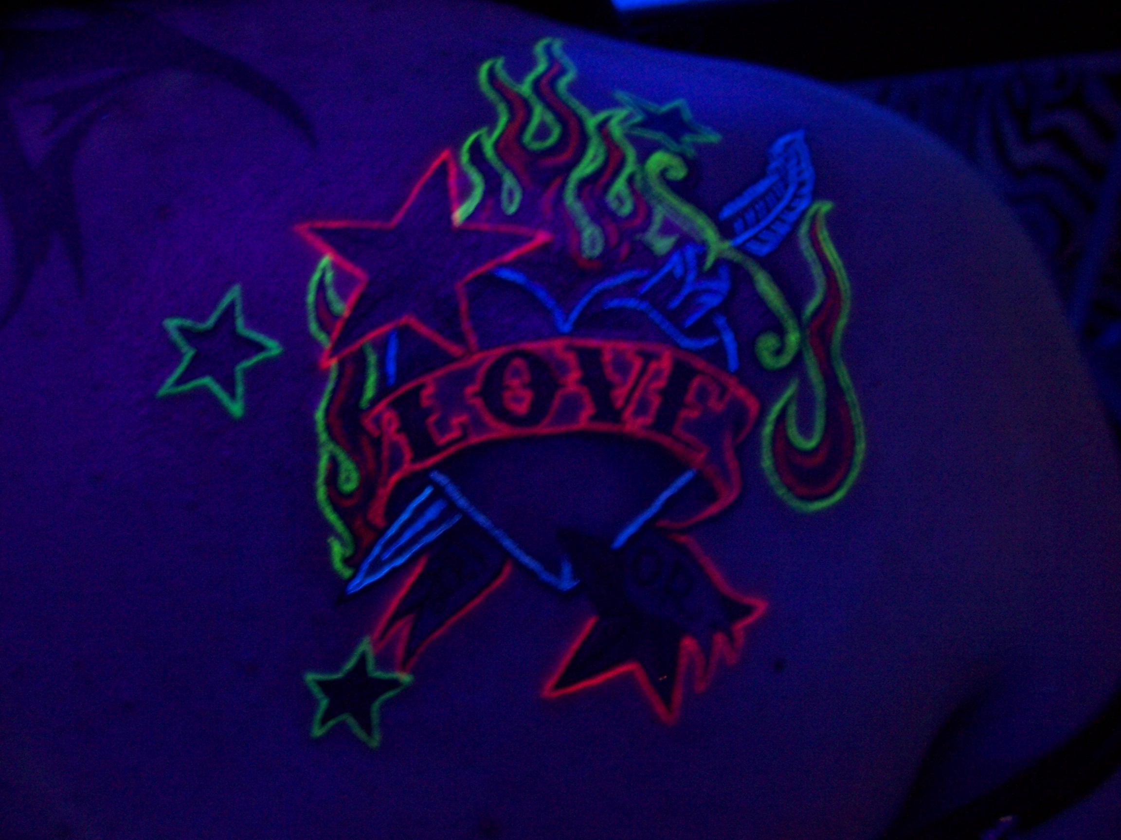 Blacklight Dagger In Heart With Banner And Stars Tattoo On Right Back Shoulder