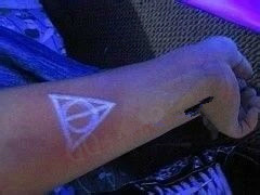 Blacklight Deathly Hallows Symbol Tattoo On Forearm