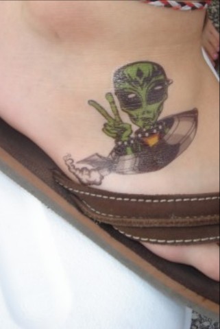 Cute Alien Sitting In Spaceship Tattoo On Foot