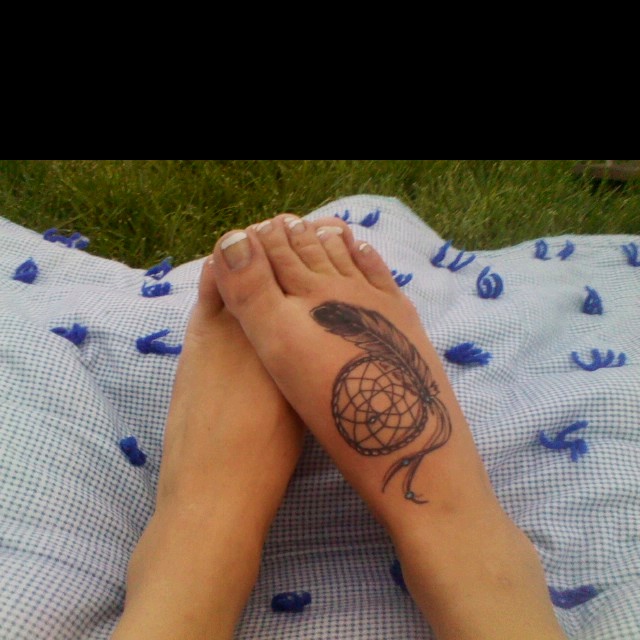 Girl Showing Her Dreamcatcher Tattoo On Foot