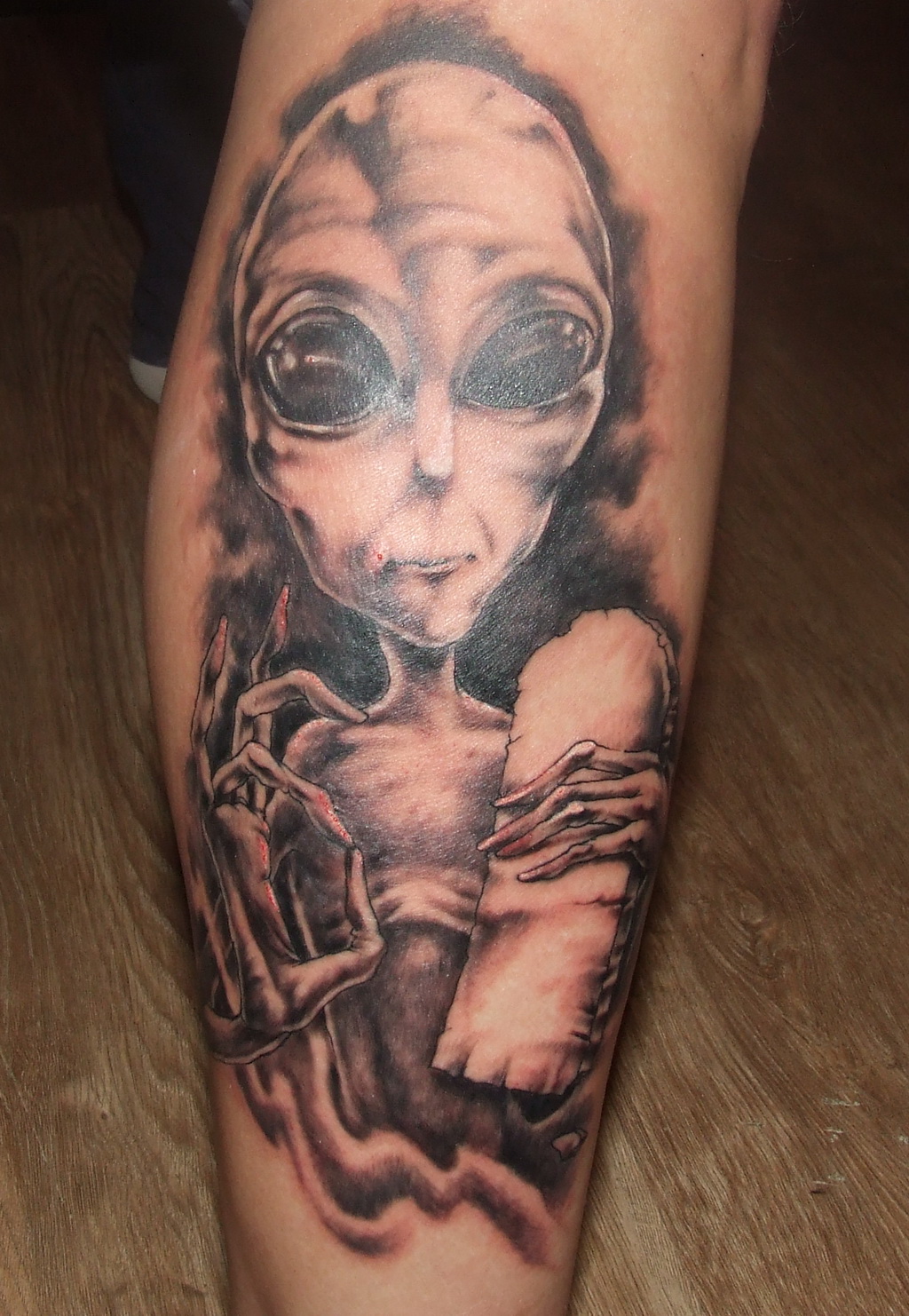 Grey Ink Alien Tattoo On Right Leg