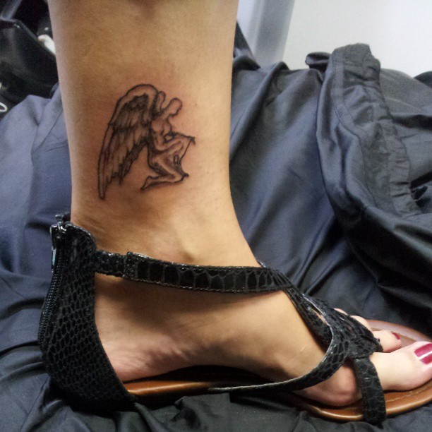 Grey Ink Small Male Angel Tattoo On Left Ankle