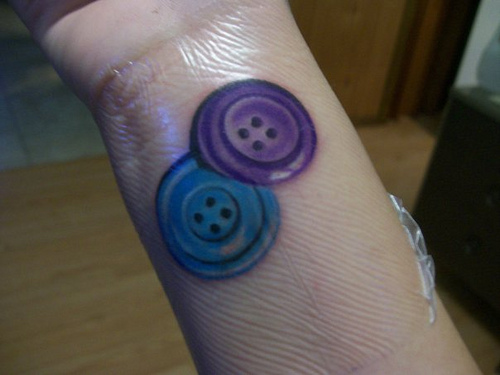Purple And Blue Two Buttons Tattoo On Wrist