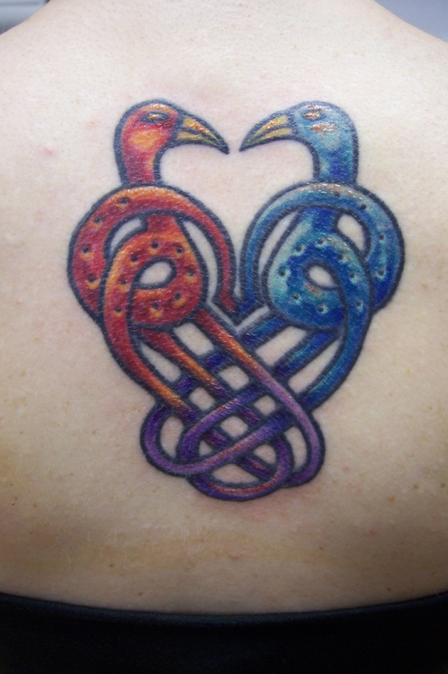 Red And Blue Ink Celtic Love Tattoo On Upper Back