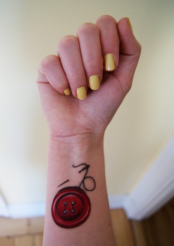 Red Ink Button Tattoo On Girl Wrist