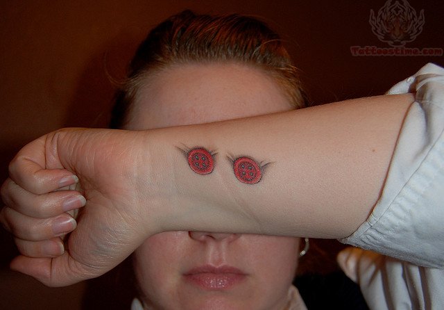 Red Ink Two Buttons Tattoo On Girl Wrist