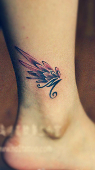 Small angel wing with alphabet M Tattoo on leg (just above ankle)
