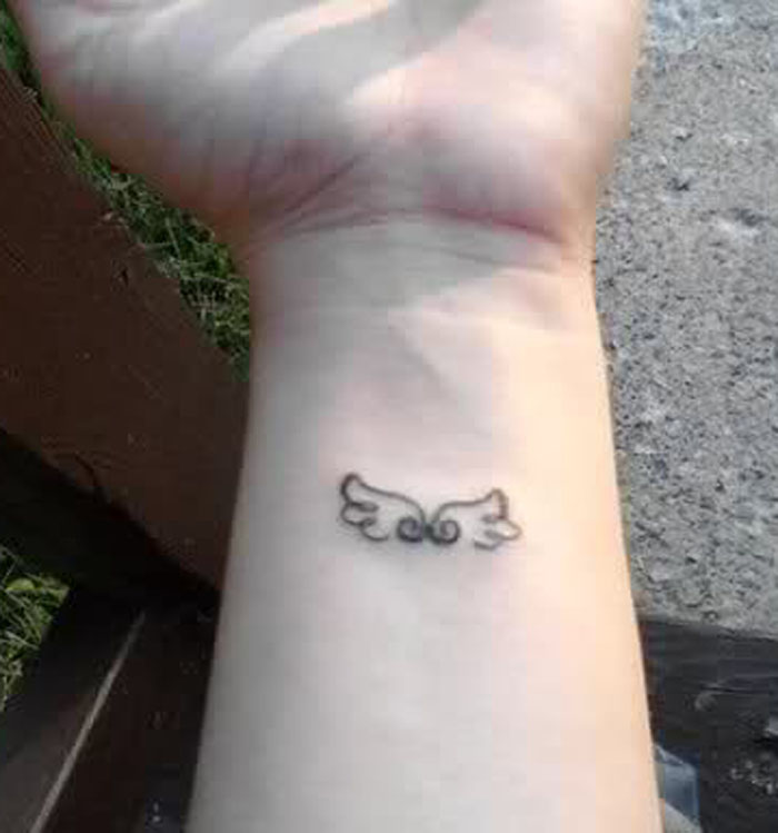 Small angel wings tattoo on wrist 2